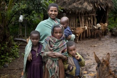 Balaynesh Kasa 27, a female farmer and beneficiary of the Debre Yacob Learning Watershed Restoration Project in Bahir Dar, Ethiopia. Photographed with her avocado trees, animals, beehives and waterpump and her 4 children
Eyrus 12, Ambtebal 9, Berekt 6 and Asmara 1 and a half yrs.
She says, “What we got from the project was the plants - 8 years ago, banana plants, avocado plants and hops
Before we had nothing.
When the project supported us we got all this benefit, for example the bananes, the kids eat them and I can sell them in the market, the hops I sell and I buy all the merchandise for the house like coffee, pepper, onions, oil, salt, meat, clothes for the kids, I can buy Medicines when they are sick, i buy all this just by selling the hops. In the past we struggled a lot. Now I can support my family and spend time with my kids (before I was sat in the market every day as a small trader) and I am so happy with this support, it has changed my life and I am so happy. All my kids can go to school now whereas before I might only have been able to send one. I would love my kids to be doctors and go further than I did.
I also have a beehive and a water pump.”