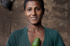 Balaynesh Kasa 27, a female farmer and beneficiary of the Debre Yacob Learning Watershed Restoration Project in Bahir Dar, Ethiopia. Photographed with her avocado trees, animals, beehives and waterpump and her 4 children
Eyrus 12, Ambtebal 9, Berekt 6 and Asmara 1 and a half yrs.
She says, “What we got from the project was the plants - 8 years ago, banana plants, avocado plants and hops
Before we had nothing.
When the project supported us we got all this benefit, for example the bananes, the kids eat them and I can sell them in the market, the hops I sell and I buy all the merchandise for the house like coffee, pepper, onions, oil, salt, meat, clothes for the kids, I can buy Medicines when they are sick, i buy all this just by selling the hops. In the past we struggled a lot. Now I can support my family and spend time with my kids (before I was sat in the market every day as a small trader) and I am so happy with this support, it has changed my life and I am so happy. All my kids can go to school now whereas before I might only have been able to send one. I would love my kids to be doctors and go further than I did.
I also have a beehive and a water pump.”