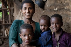 Balaynesh Kasa 27, a female farmer and beneficiary of the Debre Yacob Learning Watershed Restoration Project in Bahir Dar, Ethiopia. Photographed with her avocado trees, animals, beehives and waterpump and her 4 children
Eyrus 12, Ambtebal 9, Berekt 6 and Asmara 1 and a half yrs.
She says, “What we got from the project was the plants - 8 years ago, banana plants, avocado plants and hops
Before we had nothing.
When the project supported us we got all this benefit, for example the bananes, the kids eat them and I can sell them in the market, the hops I sell and I buy all the merchandise for the house like coffee, pepper, onions, oil, salt, meat, clothes for the kids, I can buy Medicines when they are sick, i buy all this just by selling the hops. In the past we struggled a lot. Now I can support my family and spend time with my kids (before I was sat in the market every day as a small trader) and I am so happy with this support, it has changed my life and I am so happy. All my kids can go to school now whereas before I might only have been able to send one. I would love my kids to be doctors and go further than I did.
I also have a beehive and a water pump.”