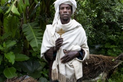 Priest Kes Yizengaw Tamir with his beehives at hiis home in the Debre Yacob Watershed LEarning Restoration Project in Bahir Dar, Ethiopia.

He says, “Life is so much better now.  We have the bees, avocados, oranges, hops, coffee, and can sell the xtra and buy what we need for the family, like medicines and school”.