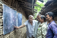 Farmers looks at sattelite images printout of Kanji village before CFR rights 2009 & after CFR rights in 2017  to see how their villages forest cover is improved after their practices after the village meeting in Sagai village.